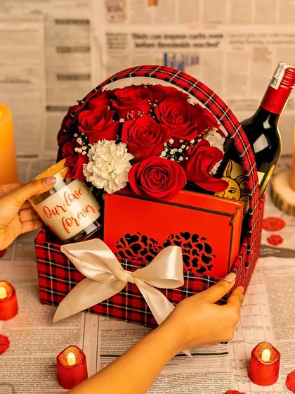 A romantic hamper with a red plaid theme, featuring fresh roses, a personalized candle, and a bottle of non-alcoholic wine.