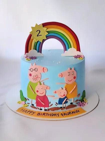 This Peppa Pig cake is perfect for a second birthday. It features the whole Peppa Pig family enjoying a sunny day under a rainbow.