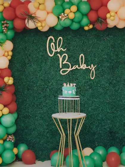 "Oh Baby!" This simple and elegant baby shower decor features a greenery wall backdrop and a colourful balloon garland, creating a fresh and modern look for the celebration.