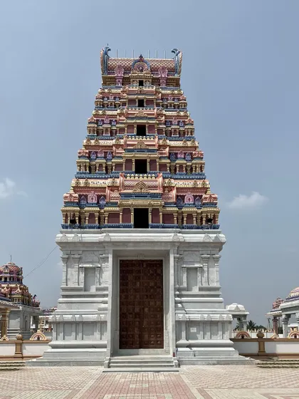 The grand wooden door of the Gopuram, set within the stone structure, marks the threshold into the main temple area.