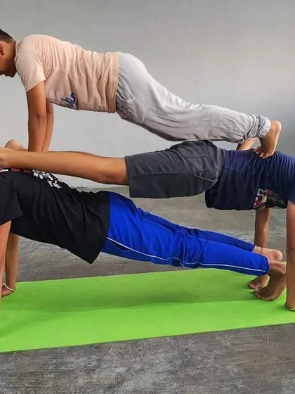 A three-person plank stack, demonstrating incredible collective strength and balance from the ground up.