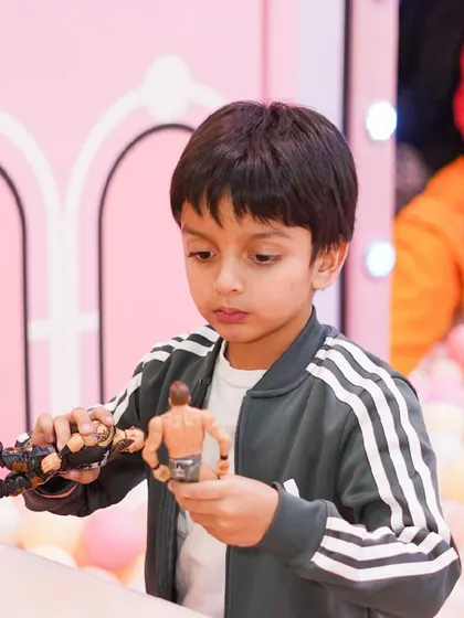 A boy plays with action figures in the ball pit.