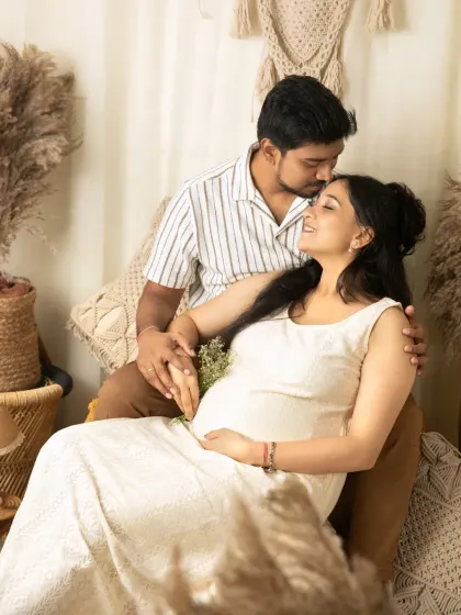 A tender moment between the couple, with a gentle forehead kiss. This pose is perfect for capturing the love and connection that is at the heart of the maternity journey.