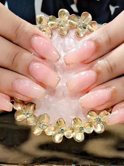 This client's natural nails were strengthened with gel and given a touch of glamour with a fine gold glitter outline.