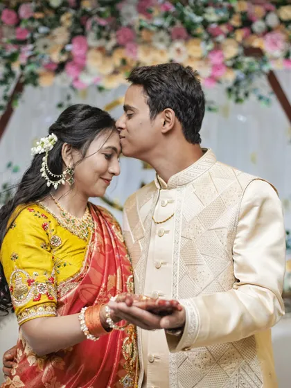 A tender moment captured as the groom kisses the bride's forehead.