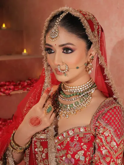 A profile view showing the elegant details of the makeup and hair. The candlelit background adds a warm, romantic glow to this regal bridal portrait.