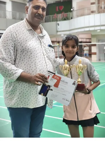 A proud father stands with his daughter, Shristi, the U-11 runner-up at the Racket Rider Tournament. We see our academy as a family, and parental support is a huge part of our community.