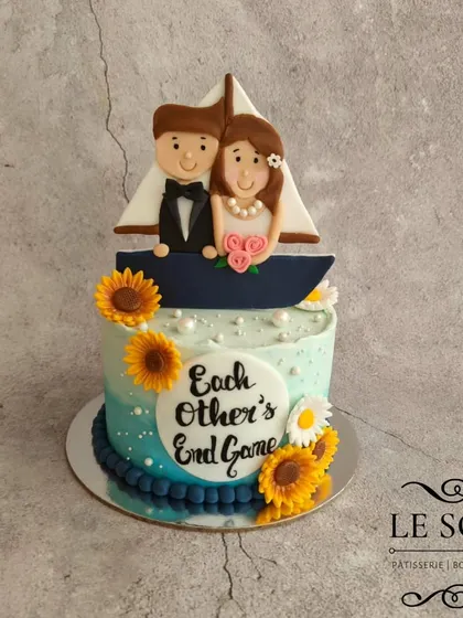 This bridal shower cake features a sweet 2D fondant couple in a boat, with the phrase "Each Other's End Game." Using 2D details is a great way to get a custom look with less fondant.