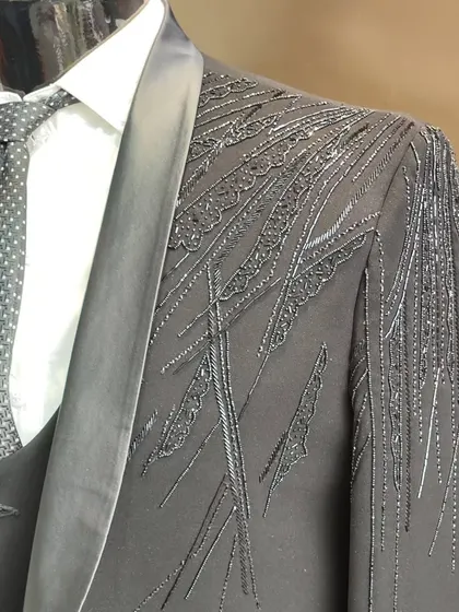 A close-up of a grey designer suit with intricate hand embroidery. The detail work on the shoulder is a perfect example of my bespoke craftsmanship.