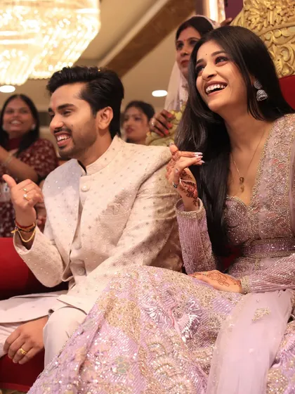 A candid shot of the couple enjoying the festivities during their engagement ceremony, surrounded by family.