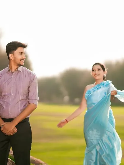 A candid moment of a couple enjoying the outdoors, with the bride's saree adding a splash of color and movement.