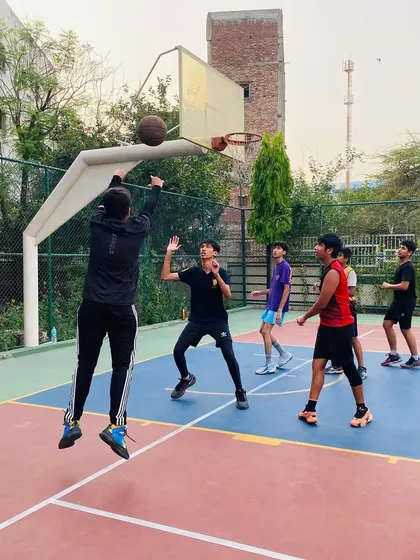 A player jumps for a shot in the key during an intense evening practice match.