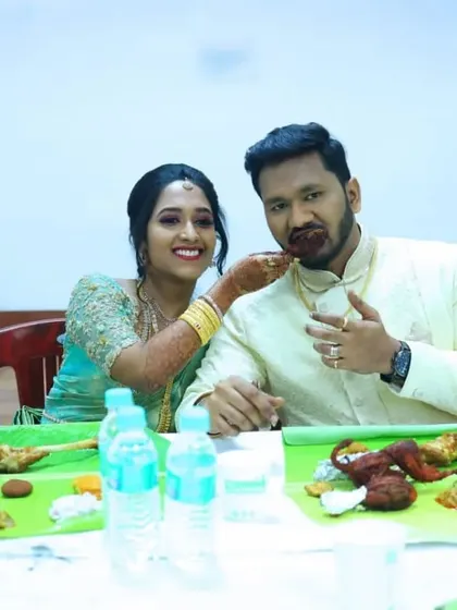 The bride lovingly feeds the groom, a sweet moment during their wedding feast.