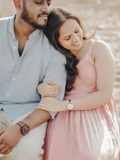 A serene and intimate portrait. This pose feels natural and relaxed, capturing a quiet moment of togetherness during their beach photoshoot.
