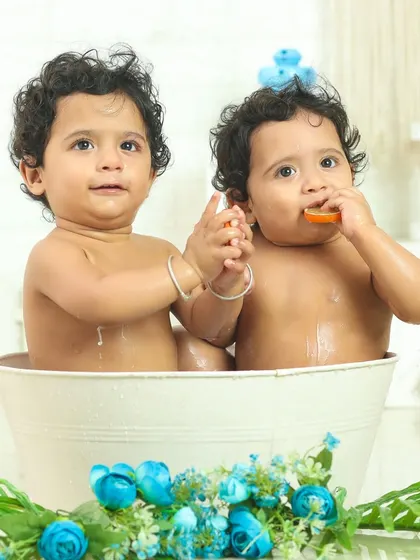 Two little faces, one tub of fun. This twin bath time photo captures their curiosity and the special connection they share.
