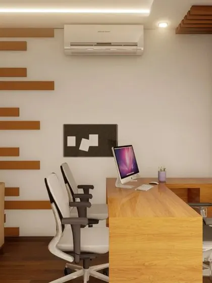 A view of the office interior showing the main desk, visitor chairs, and a comfortable sofa for informal meetings. The wood accent on the wall adds texture and warmth.