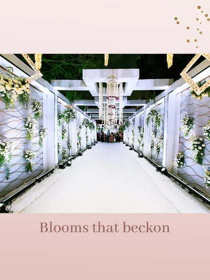 Blooms that beckon to the path of love. This elegant white walkway, lined with floral arrangements, created a sophisticated and welcoming entrance for the wedding guests.