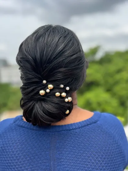 A slightly different angle of the classic low bun, showing the placement of the decorative pins.