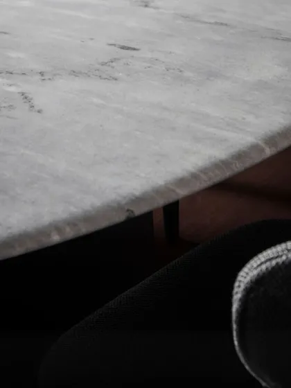 A close-up on the edge of the Stealth Marble Table, showing the natural veining and thickness of the stone. Every piece is unique, bringing a touch of nature's artistry into your home.