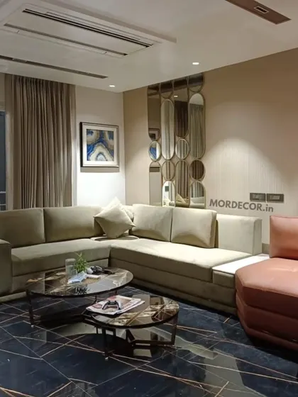 A complete living room designed and furnished by us. This space features a custom L-shaped sofa, a nested marble-top center table, and a unique leather armchair, all set against a dark marble floor for a modern, luxurious feel.