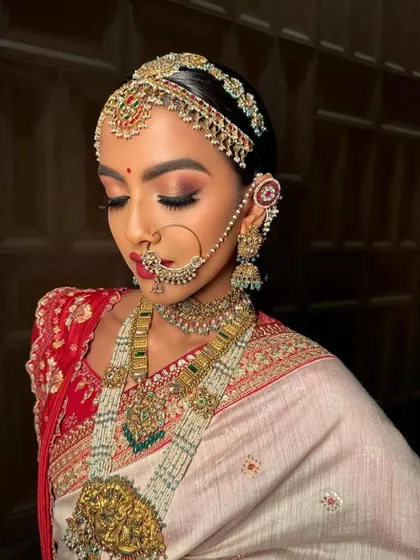 A traditional Rajasthani-inspired bridal look. The makeup features a warm, coppery eye and a bold red bindi, capturing the royal essence of the region.