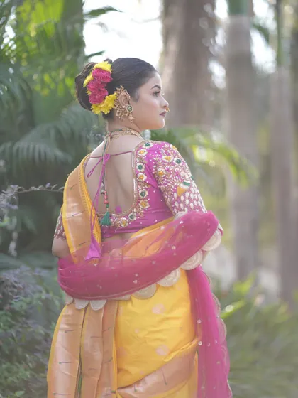 This is the classic Maharashtrian bridal bun, my specialty. I meticulously craft the bun to be neat and secure, providing the perfect base for fresh flowers and traditional hair jewelry. This style is designed to hold perfectly throughout a long day of ceremonies.