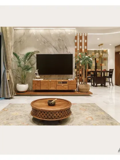 A wider view of the living and dining area. This image shows how we create a cohesive flow between spaces using elements like a wooden partition and a consistent material palette.