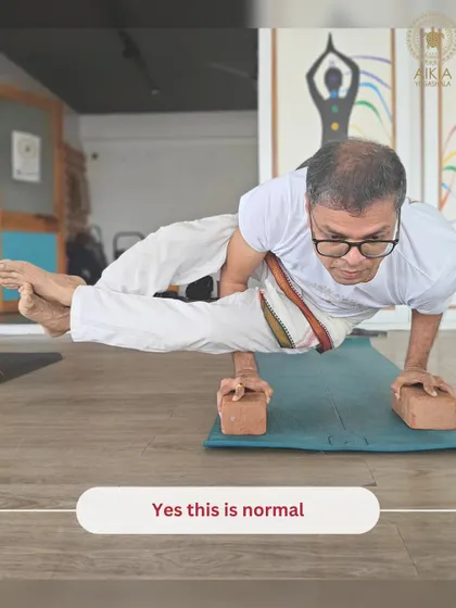 "Yes this is normal." A senior student demonstrates incredible strength in an arm balance on blocks, proving that age is no barrier to advanced practice at our shala.