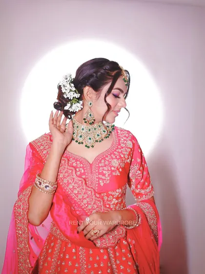 A portrait showing the beautiful floral bun that pairs perfectly with this traditional pink lehenga.