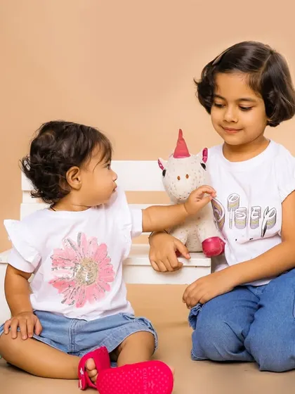 A quiet moment of play between two sisters during their studio photoshoot. We encourage natural interactions to capture the authentic bond that siblings share.