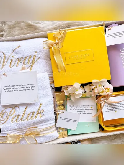A closer look at the hamper we curated for Viraj and Palak, showcasing the elegant gold embroidery on the towels and a personalized 'Hydrate' bottle.