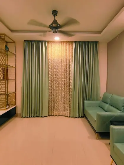 The same sage green curtains, shown here with a sheer inner layer that allows for diffused natural light while maintaining privacy.