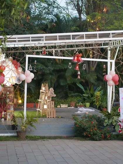 An outdoor Christmas-themed birthday party entrance, featuring a Santa Claus cutout and a personalized welcome sign.