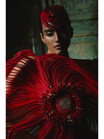 A powerful close-up portrait from the Vaishali S campaign. The model's direct gaze, combined with the dramatic red headpiece and garment, creates an image that is both beautiful and intense.