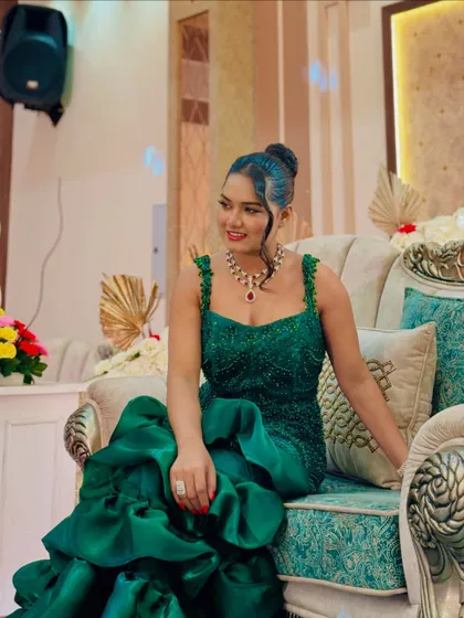 A seated portrait in the emerald green gown. The intricate beadwork and rich color make it a standout piece.
