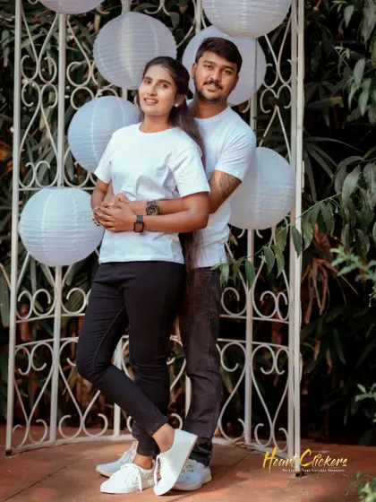 A sweet embrace from behind, with the couple in matching white tees. This pose is classic, romantic, and shows their strong connection.