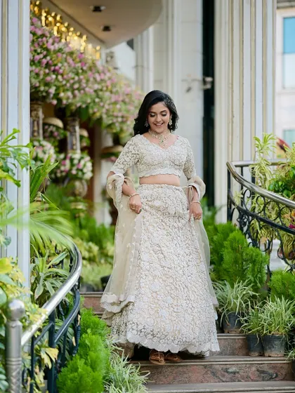 A bride walking down the stairs, her hair in a simple yet elegant open style with soft curls. This look is perfect for a reception, allowing for easy movement.
