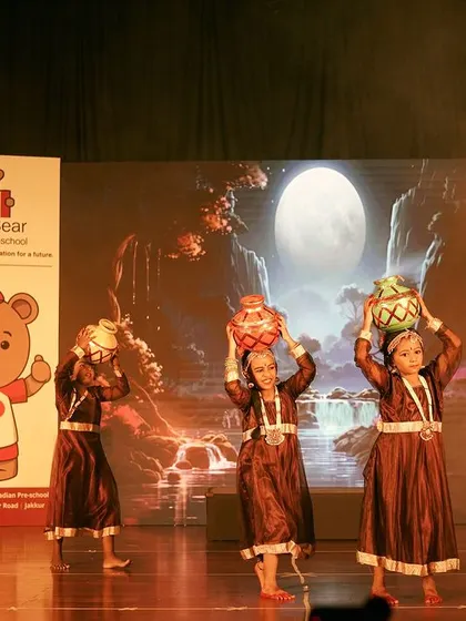 A beautiful shot of students performing a traditional dance with pots, set against a stunning digital backdrop. My event production services include sourcing and managing high-quality audio-visual equipment for an immersive experience.