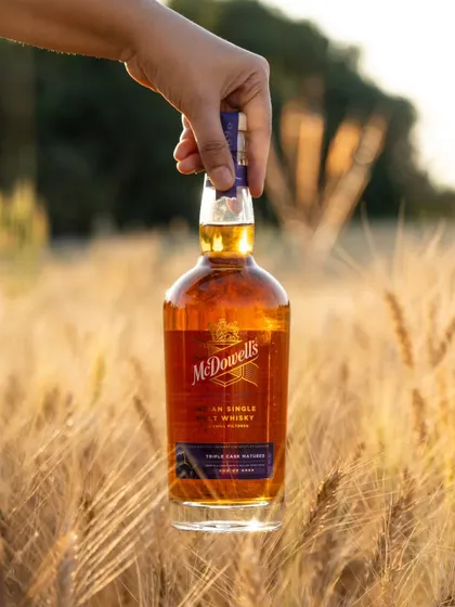 A similar shot of the McDowell's bottle in a wheat field, connecting the whisky directly to its grain origins.