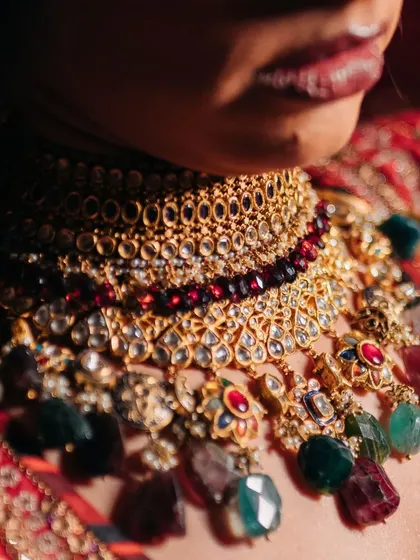 A detailed shot of the bride's handcrafted Kundan necklace, featuring uncut diamonds (polki) and drops of emeralds and rubies, a masterpiece of traditional jewelry design.