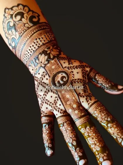 This back-of-hand design features a small elephant motif, floral patterns, and a detailed wrist cuff. It's a unique and artistic choice for any event.