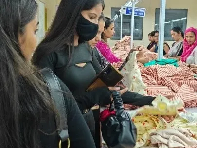 Students inspect finished garments in the quality control department, learning about international standards in the apparel industry.