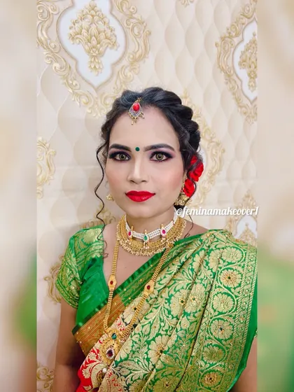 A soft and elegant look for a Maharashtrian ceremony. The makeup is subtle with a bold red lip, and the hair is styled in a gentle updo with fresh red roses.