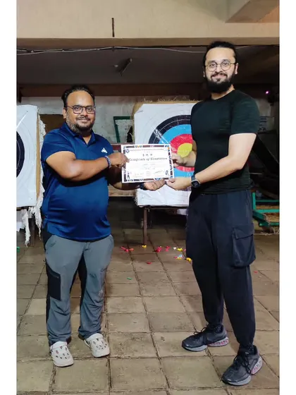 This archer receives his certificate in front of the targets he spent the camp mastering.