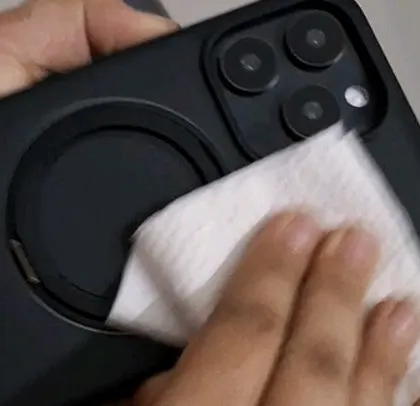 Carefully cleaning the iPhone case before the shot to ensure a perfect, fingerprint-free image.