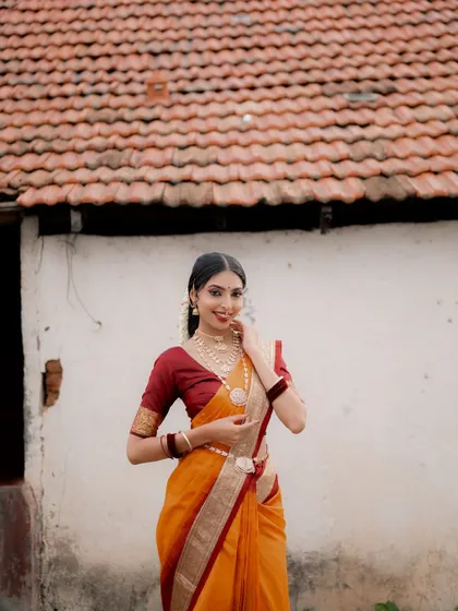 A happy, smiling portrait in the same traditional attire. This shot, set against a rustic village home, feels authentic and rooted in culture.