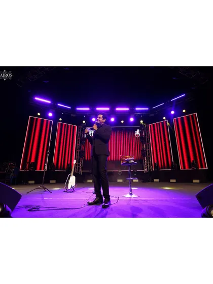 A wide shot of a performer alone on a large stage, emphasizing the scale of the venue and the artist's command of the space.