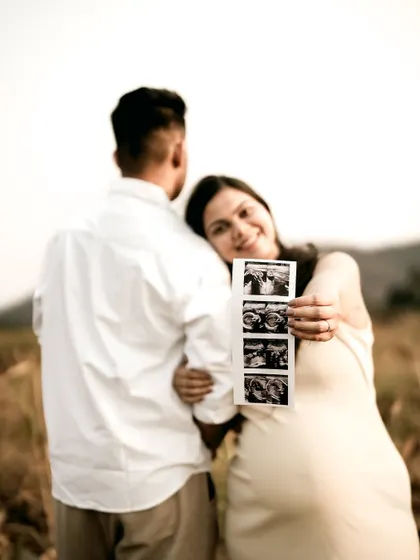 A creative shot where the mom-to-be leans against her partner, holding out the sonogram for the camera. It’s a lovely way to include both the couple and the baby-to-be in one frame.