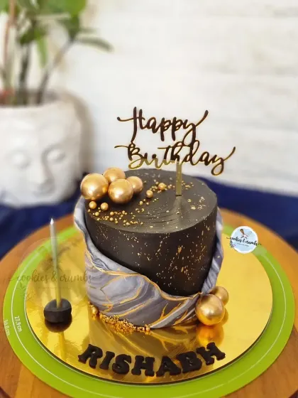 I love the effect of fondant marbling. This black and grey marbled cake with gold spheres and a "Happy Birthday" topper is a great example of a modern and masculine design.