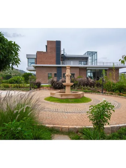 This is a duplicate of ID 85. The circular driveway and central water feature create a formal yet inviting entrance to the Nandi Hills property.